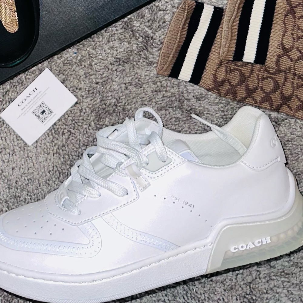 All white Coach sneakers with transparent rim.